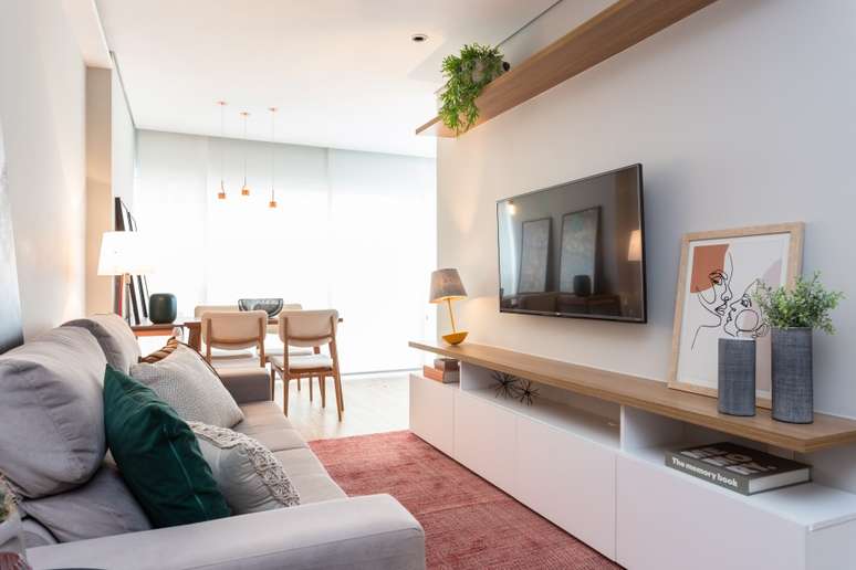 Com a &aacute;rea social integrada, o projeto atemporal proposto pelo Studio Tan-gram levou em conta uma grande demanda das pessoas atualmente: o retorno ao natural, com a madeira em posi&ccedil;&otilde;es espec&iacute;ficas do d&eacute;cor e plantas que prop&otilde;e pontos verdes e org&acirc;nicos na sala