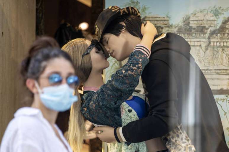 Turista passeia diante de vitrine no centro de Roma, capital da Itália