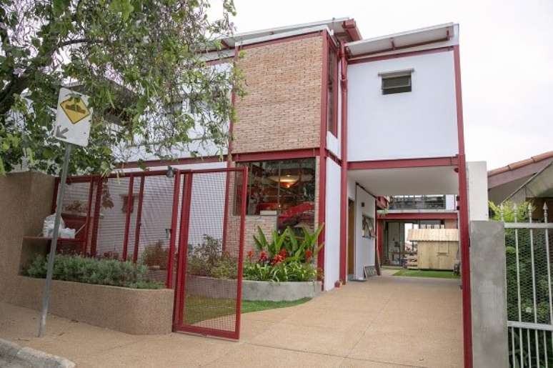 45. Fachada de casa com parede de tijolinho aparente e estrutura metálica vermelha. Fonte: C2HA Arquitetos
