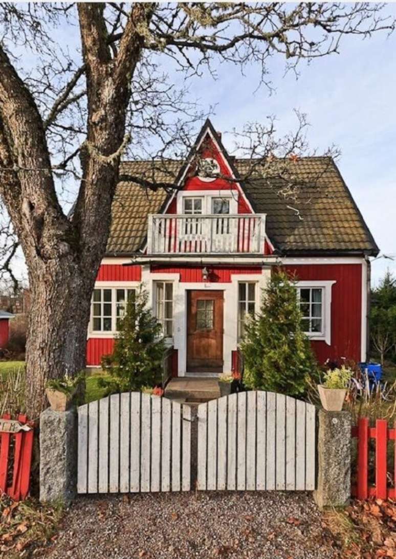 22. Casa vermelha com portão de madeira branco. Fonte: Casual Love Elegance