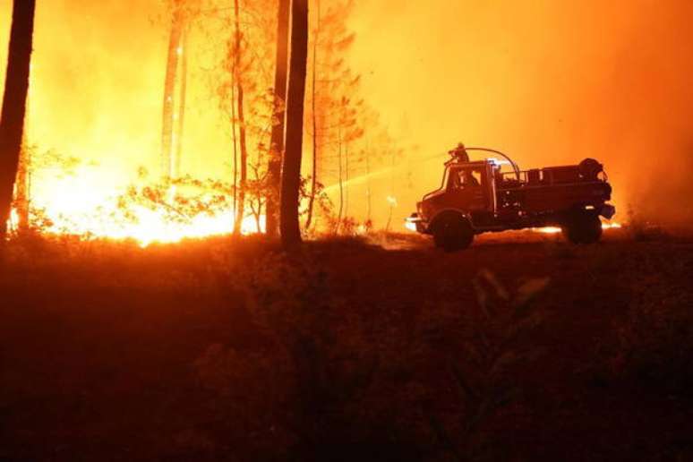 Bombeiros tentando conter as chamas em uma floresta em Gironde