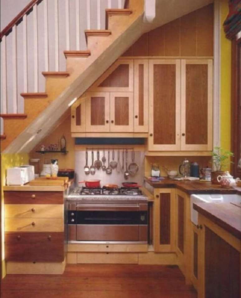 27. Mini cozinha com armários e gavetas projetada embaixo da escada. Fonte: Roderick Zanini