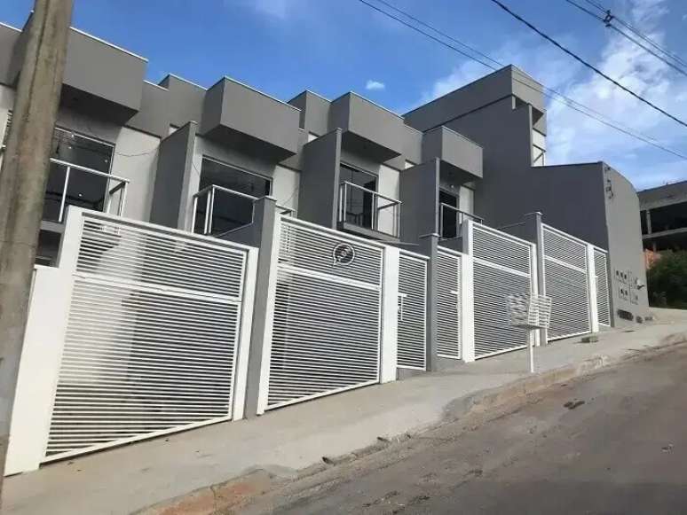 75. Cores de casas geminada com fachada cinza e portão branco. Fonte: Wimoveis