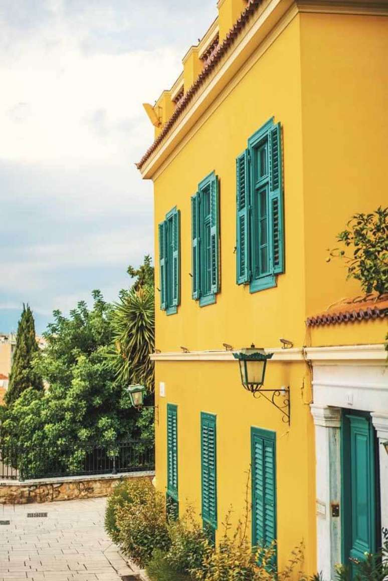 97. Fachada de casa amarela com janelas em azul petróleo. Fonte: Bounce