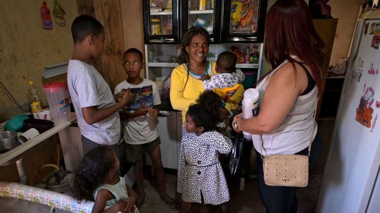 Célia Barros (de amarelo) recebeu doações após seu filho Miguel (segundo à esquerda), de 11 anos, ligar para a polícia por estar com fome, em Santa Luzia, região metropolitana de Belo Horizonte