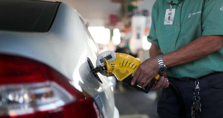 Frentista abastece carro em posto de gasolina 