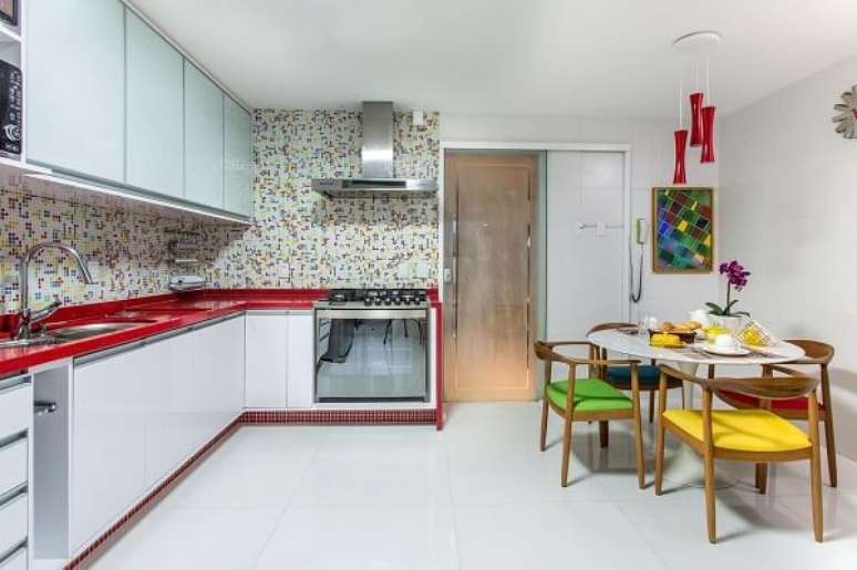 43. Cozinha planejada com bancada de granito vermelho estelar e armários brancos – Foto Milla Holtz e Bruno Sgrillo Arquitetura