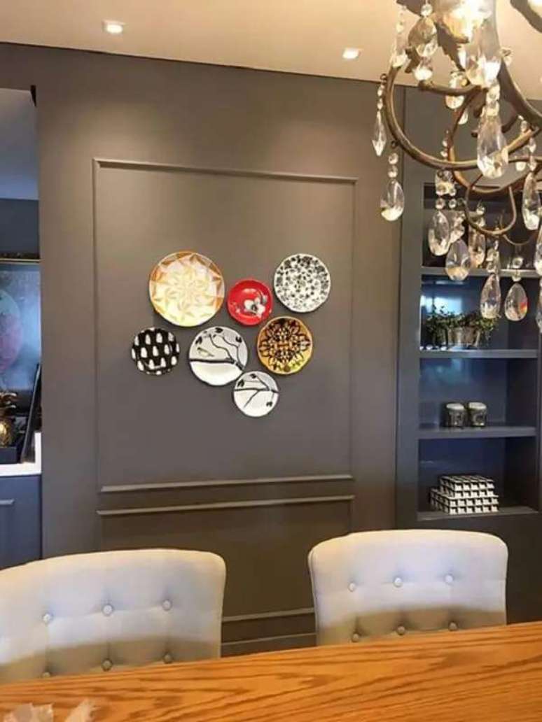 41. Os pratos decorativos se destacam na parede escura. Fonte: Semana de Design de S&atilde;o Paulo