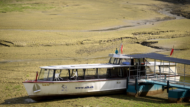 Seca está produzindo cenas como esta de um barco encalhado na lama da margem do Lago franco-suíço Brenets — agora seco