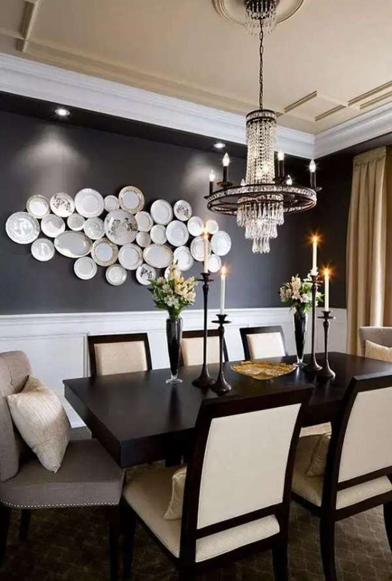 18. Sala de jantar com parede preta e pratos decorativos brancos. Fonte: Lolaf&aacute;