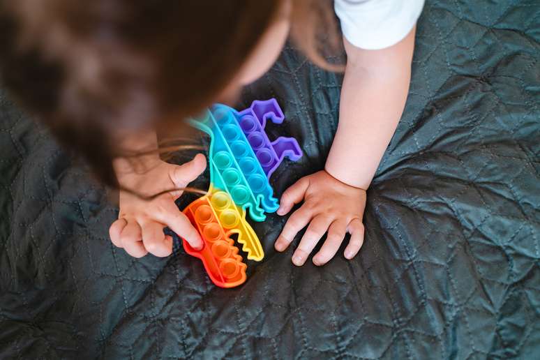 Criança brincando com Push Pop It