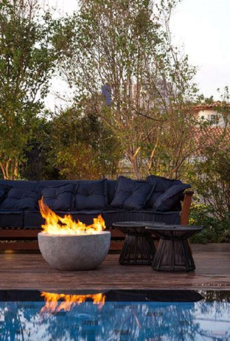 28. Sof&aacute; para &aacute;rea externa azul marinho com lareira &ndash; Foto Monica Costa