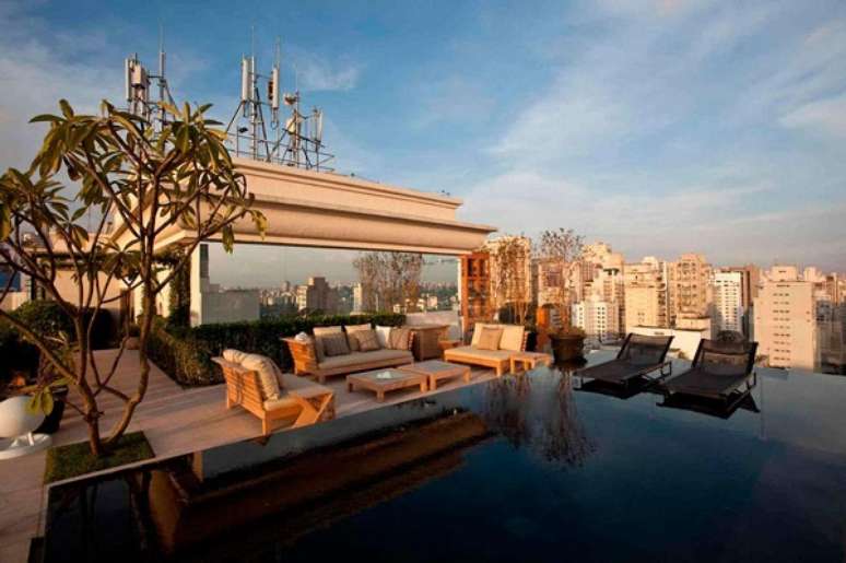 31. Sof&aacute; para &aacute;rea externa com estofado bege e piscina com borda infinita &ndash; Foto DB Arquitetos