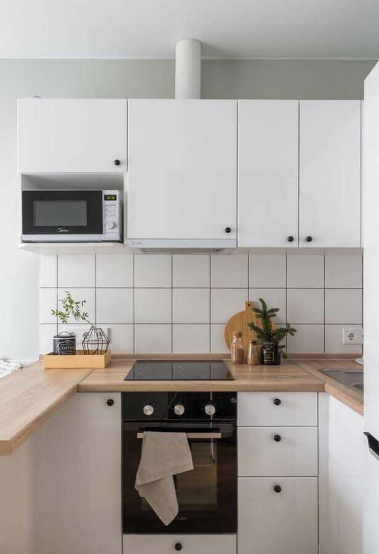 35. Cozinha completa branca com bancada de madeira – Foto: Houzz