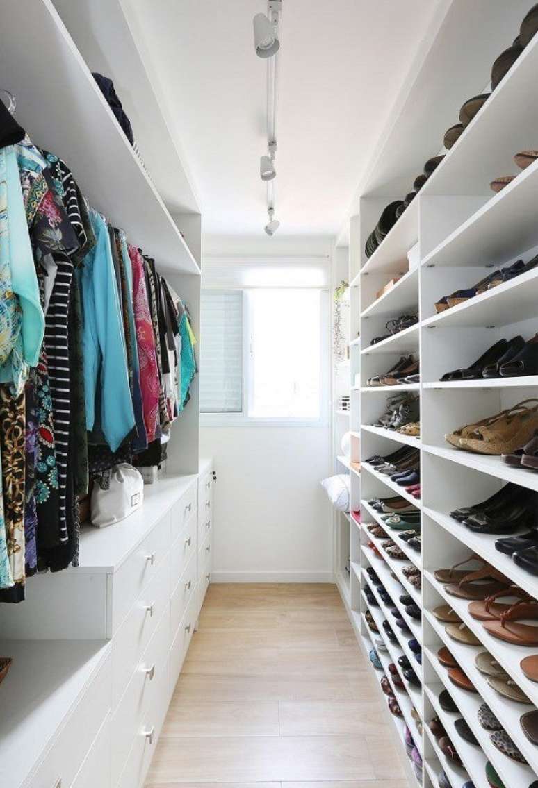 40. Sapateira de madeira grande na cor branca combinando com os nichos e gavetas de roupas &ndash; Foto Casa Abril