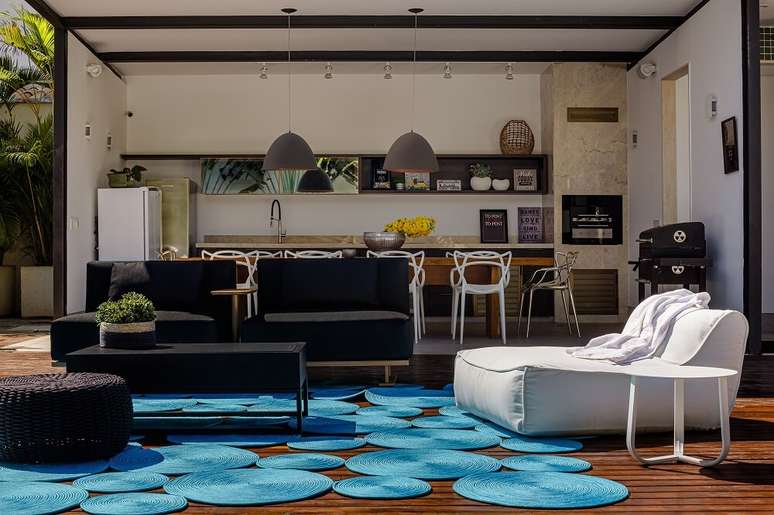 11. Ed&iacute;cula com churrasqueira, mesa de madeira e cadeiras Allegra brancas. Foto: Dhani Borges