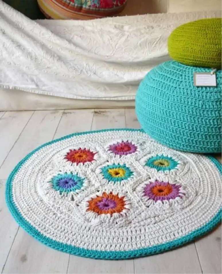 99. Modelo simples de tapete de croch&ecirc; com flores coloridas e acabamento em azul na lateral &ndash; Foto: Etsy
