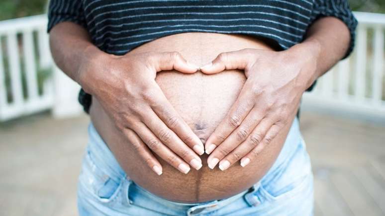 Imagem mostra barriga de mulher negra grávida.