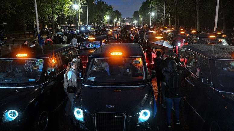 Tradicionais t&aacute;xis pretos de Londres fazem fila em homenagem na avenida que leva ao pal&aacute;cio de Buckingham