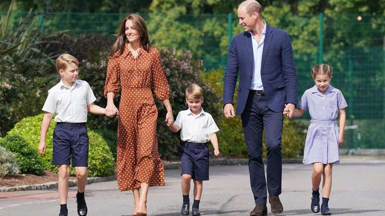 Os pr&iacute;ncipes George e Louis e a princesa Charlotte caminham de m&atilde;os dadas com os pais, o duque e a duquesa da Cornualha e de Cambridge, no primeiro dia de aula