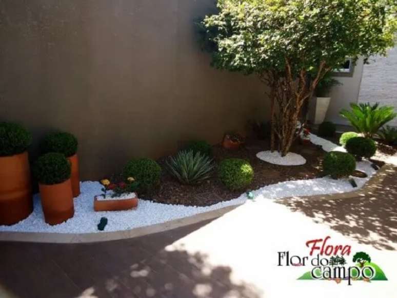 26. Canteiro formado com arbustos e pedra branca para jardim. Projeto de Flora Flor do Campo