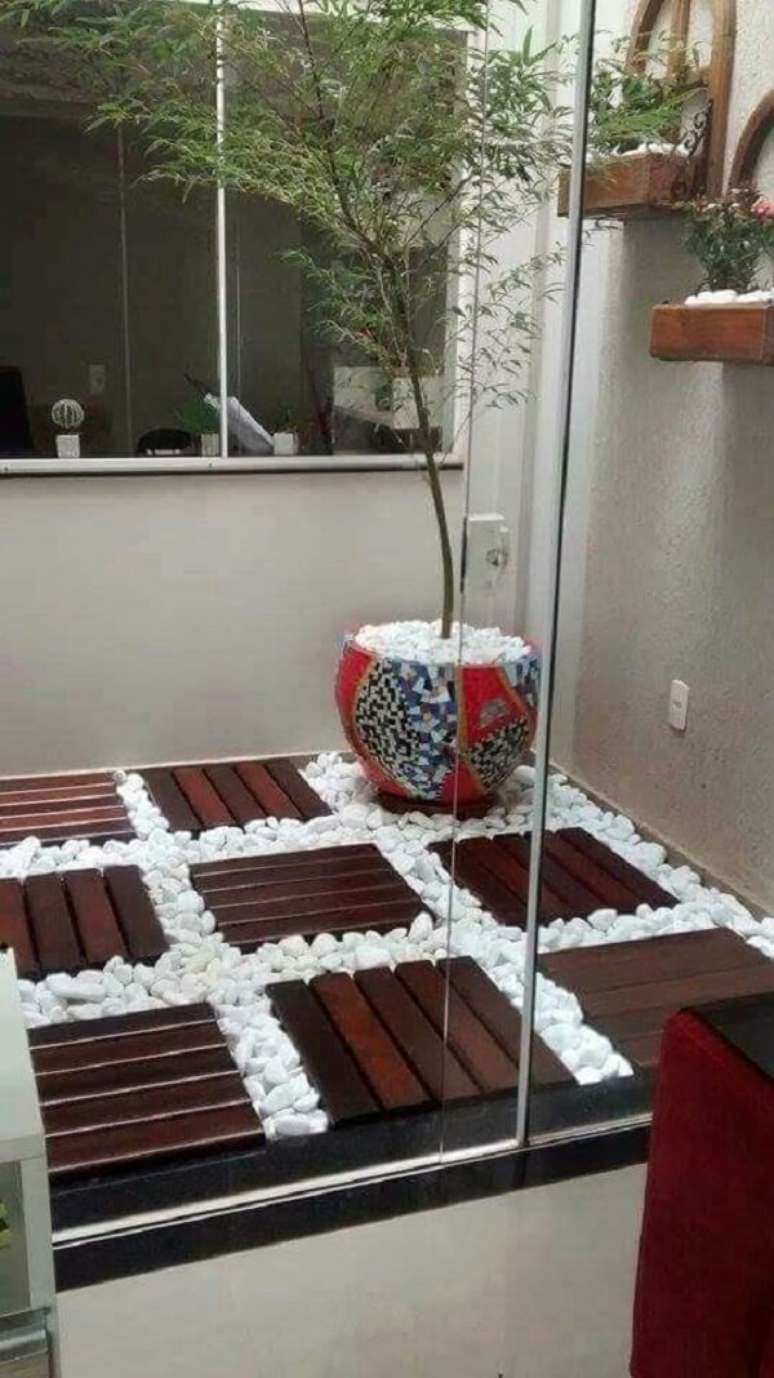 29. Deck de madeira e pedra branca para jardim. Fonte: Erika Camunas Rodriguez