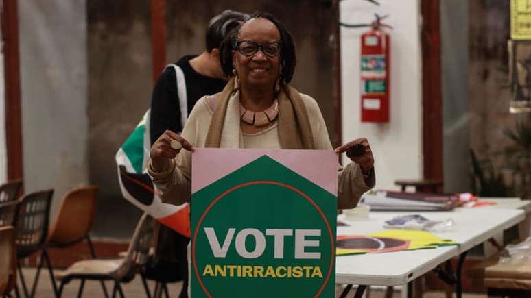 Imagem mostra Sueli Carneiro com o cartaz "Vote Antirracista", do Quilombo nos Parlamentos.