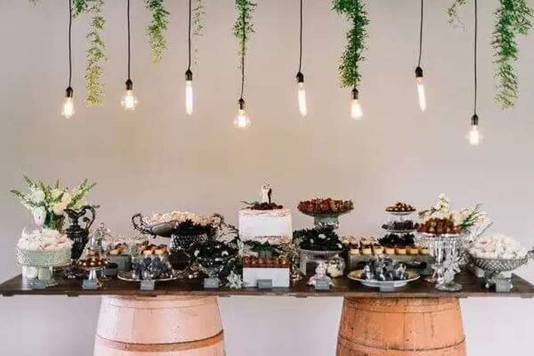 63. Na decora&ccedil;&atilde;o de casamento r&uacute;stico, os barris com tampo de vidro comp&otilde;em a mesa principal da festa. Fonte: Tudo Orna