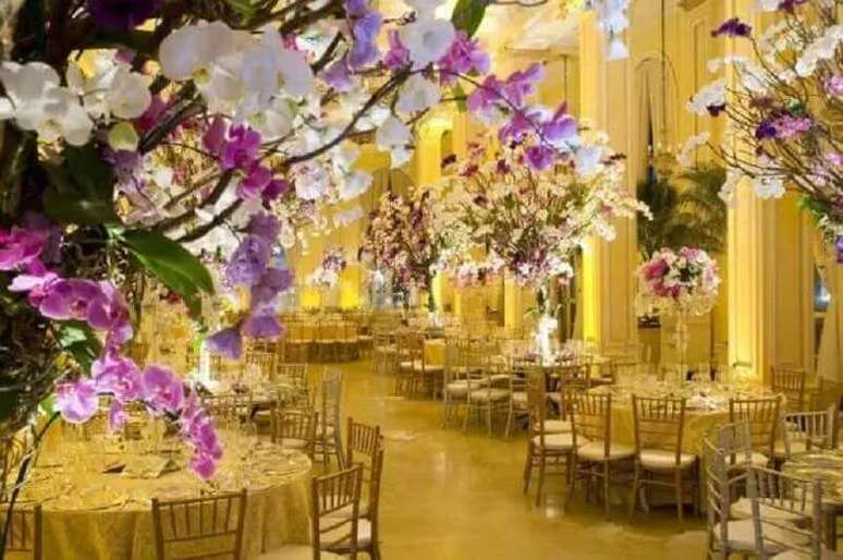 26. Essa decora&ccedil;&atilde;o de casamento recebeu muitas flores e tons de dourado