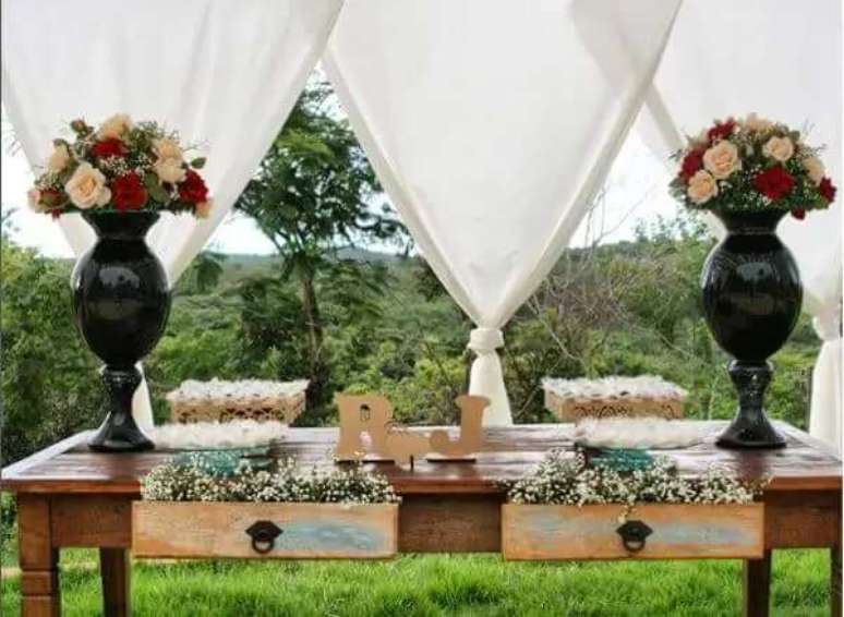 65. Na mesa que comp&otilde;e a decora&ccedil;&atilde;o de casamento, as gavetas abertas funcionam como jardineiras com mosquitinhos. Fonte: Casar &Eacute;&hellip;