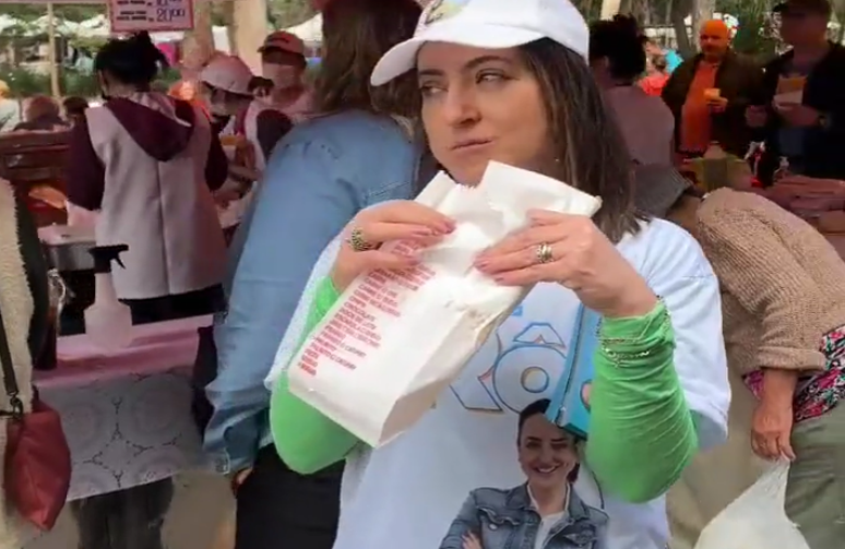 Rosângela Moro postou vídeo comendo pastel de feira e foi criticada na web por mulher aparecer atrás revirando lixo