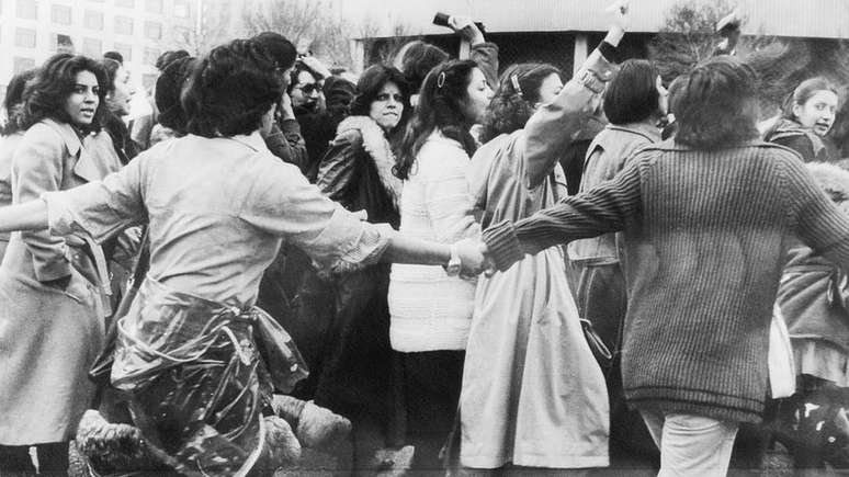 Protestos anti-hijab no Irã se estenderam por vários dias. Na foto, mulheres estão sendo protegidas por um grupo de jovens no terceiro dia de protestos em março de 1979