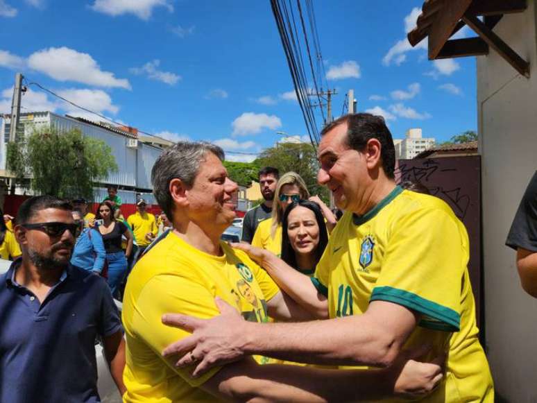 Tarcísio de Freitas cumprimenta apoiador ao chegar para votação em São José dos Campos.