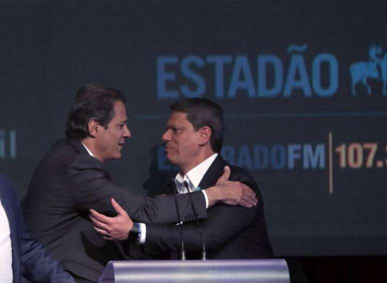 Os candidatos Fernando Haddad (PT), à esquerda, e Tarcísio de Freitas (Republicanos) se cumprimentam em debate.