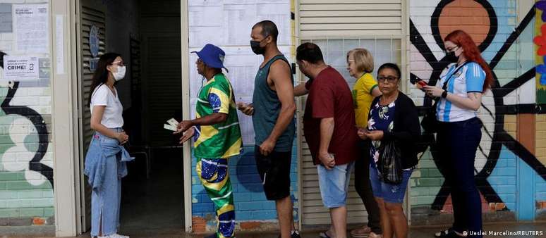 Eleitores esperam em fila para votar em Brasília (DF), no primeiro turno das eleições no Brasil, em 02/10