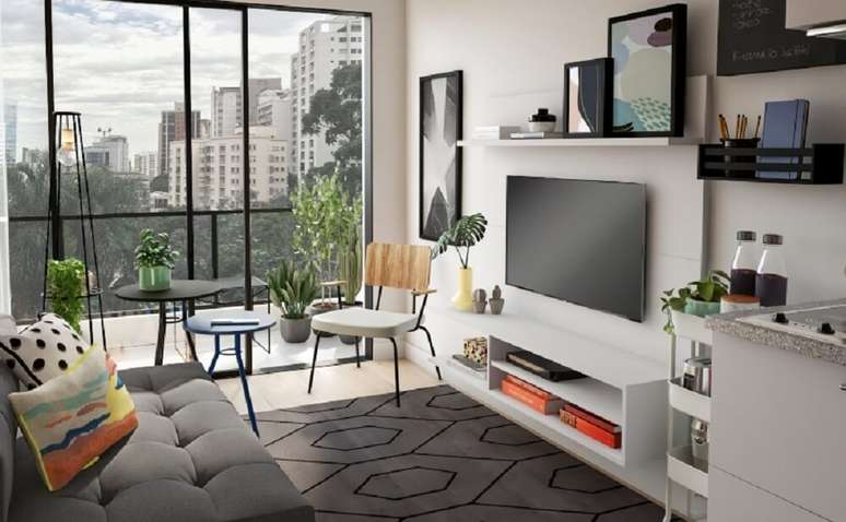 2. Arranjos de flores, quadros e livros deixam a decora&ccedil;&atilde;o do painel de TV mais personalizado. Fonte &ndash; Tok&Stok
