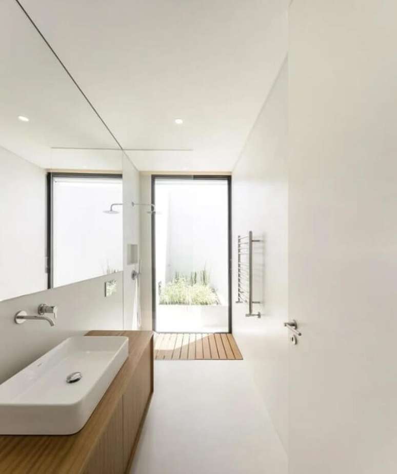 60. Banheiro sofisticado com cimento queimado branco e bancada planejada. Fonte – Colectiva Arquitectura