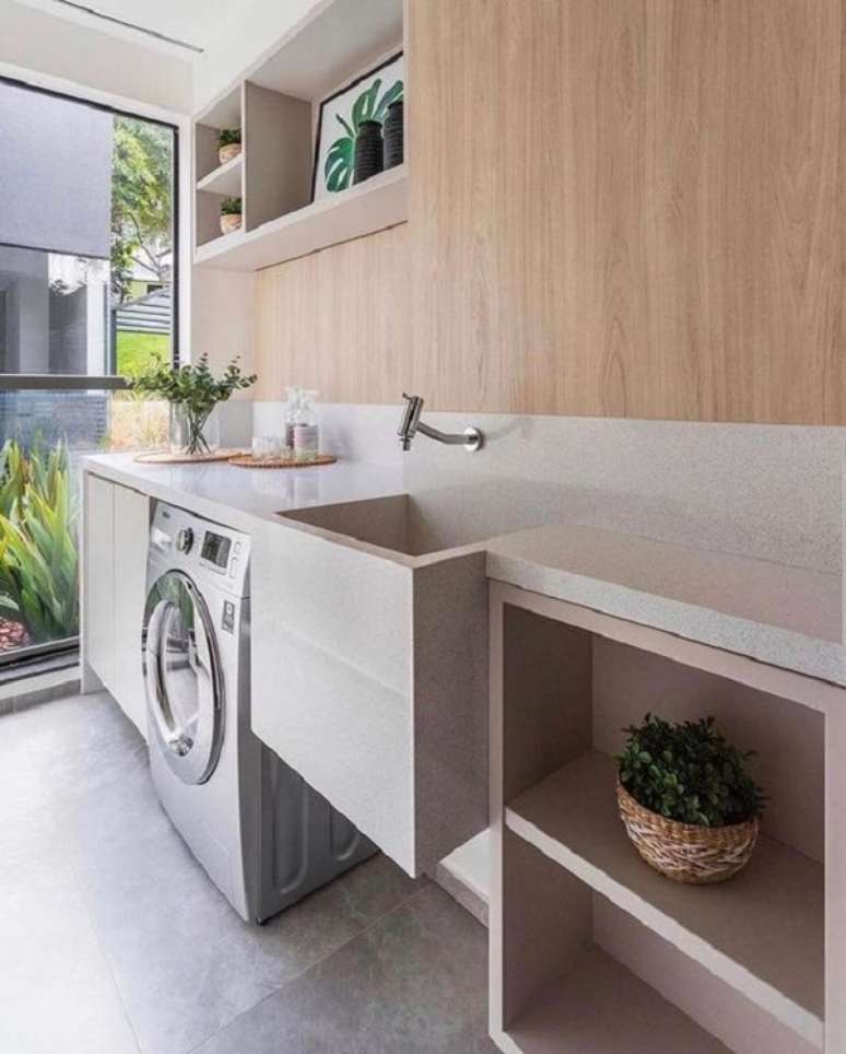 48. Tanque para lavanderia esculpido em granito e arm&aacute;rio pequeno ao lado da m&aacute;quina &ndash; Foto Maddison Moveis