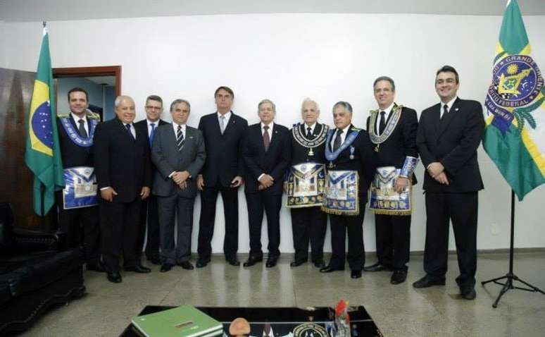 Jair Bolsonaro, Augusto Heleno e membros da maçonaria na frente de uma parede branca