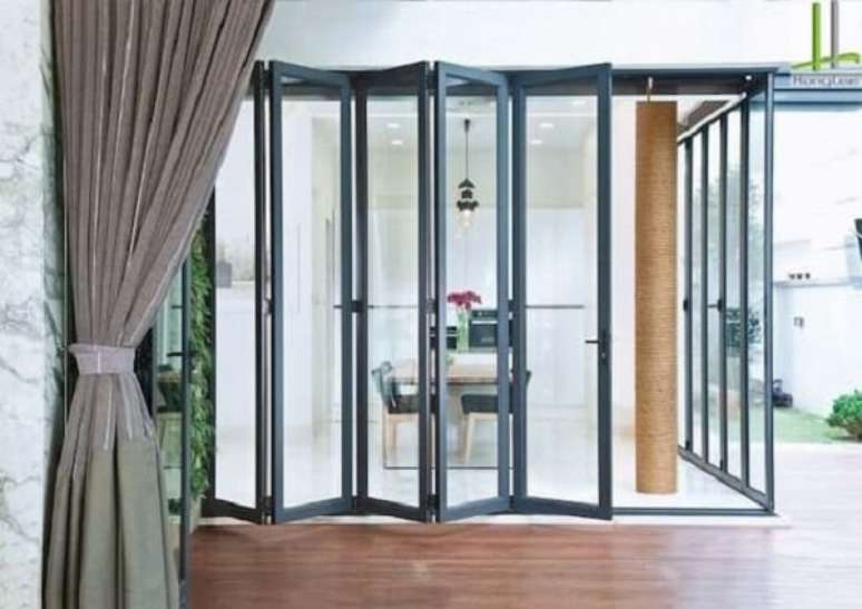 21. Porta camar&atilde;o de vidro e alum&iacute;nio para sala de estar &ndash; Foto Mundo Das Tribos