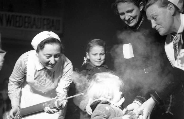 Uma menina é pulverizada com DDT na Alemanha em 1945 como parte de um programa para matar piolhos, um dos insetos que podem transmitir o tifo