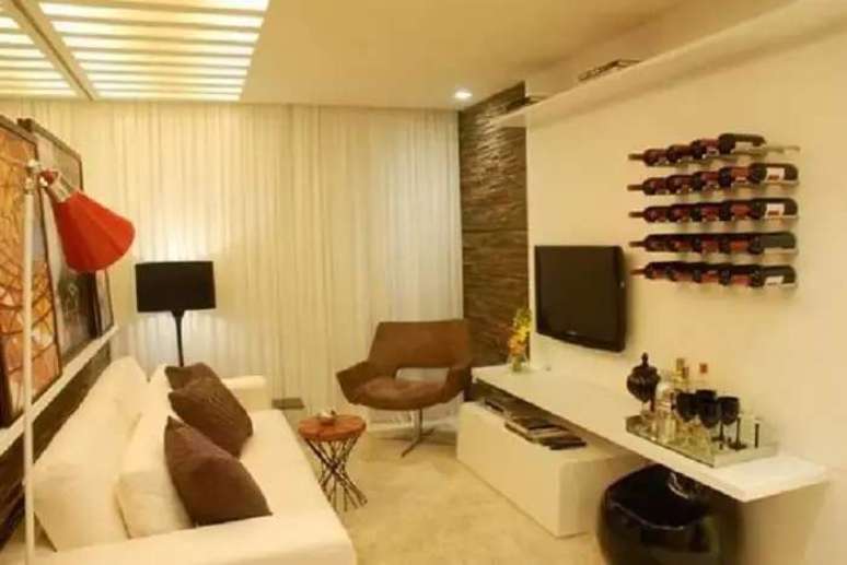 67. Suporte de garrafas na parede encantam a &aacute;rea de barzinho para sala. Fonte: Viajando no Ap&ecirc;
