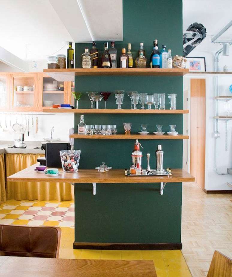 19. Parede da sala com prateleiras para guardar bebidas, ta&ccedil;as e copos. Fonte: Casa de Valentina
