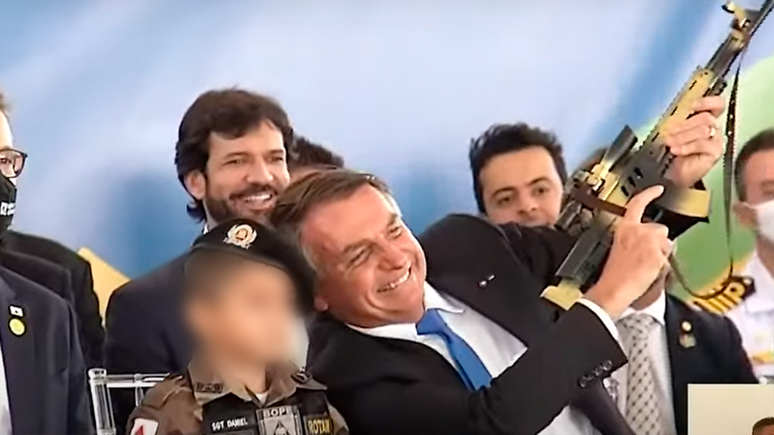Em 2021, Bolsonaro chamou uma criança fardada para se sentar ao seu lado em evento e fez gestos de tiro com réplica de arma