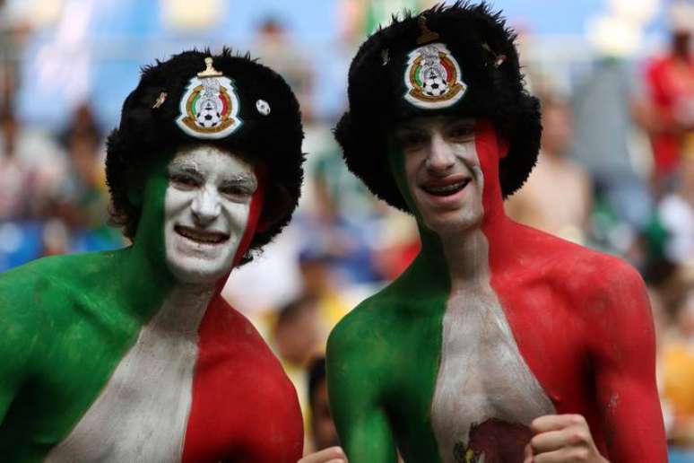 Torcedores mexicanos se pintam com a bandeira do país para acompanhar jogo de Copa do Mundo.