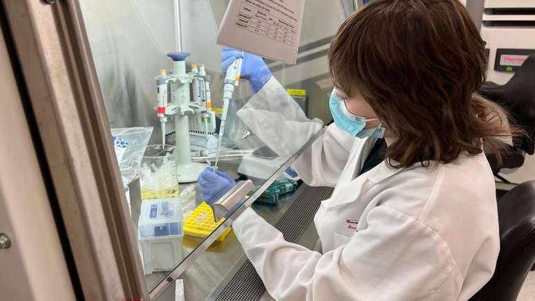 An&aacute;lise de tecidos, pesquisadora segurando tubo de ensaio