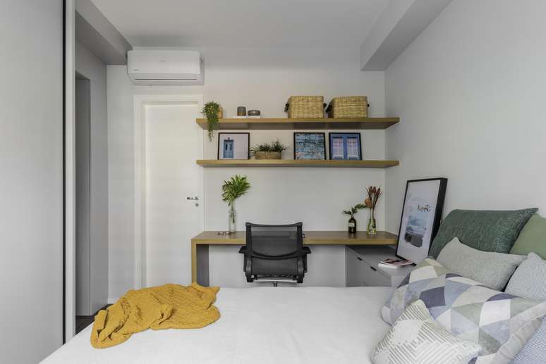 O home office também fica no quarto. Compacto e bem planejado, ele oferece todas as condições para os moradores trabalharem remotamente. Com prateleiras e gaveteiro, o local destinado ao trabalho torna-se mais organizado.