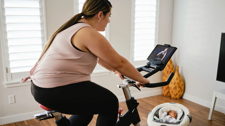 Mulher pedalando em bicicleta ergométrica