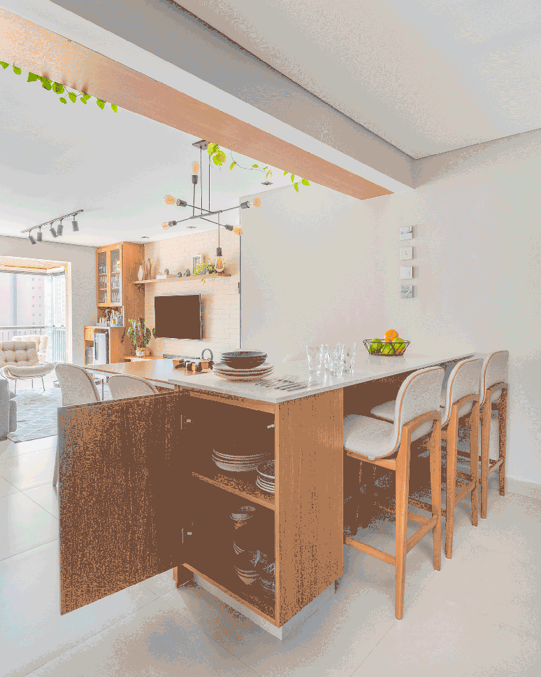 Com a cozinha integrada, &eacute; preciso ficar atento para n&atilde;o perder nenhuma oportunidade para ampliar os cantinhos de dep&oacute;sito, sempre, claro, tendo cuidado para n&atilde;o sobrecarregar o design &ndash; aqui, o m&oacute;vel exerce fun&ccedil;&atilde;o dupla de buffet, sem prejudicar a est&eacute;tica | Projeto Bruno Moraes Arquitetura.