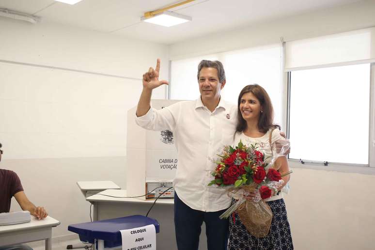 O candidato do PT ao governo do Estado de São Paulo, Fernando Haddad (c), acompanhado da esposa Ana Estela Haddad (d), vota na Brazilian Internacional School, em Indianópolis, na zona sul de São Paulo